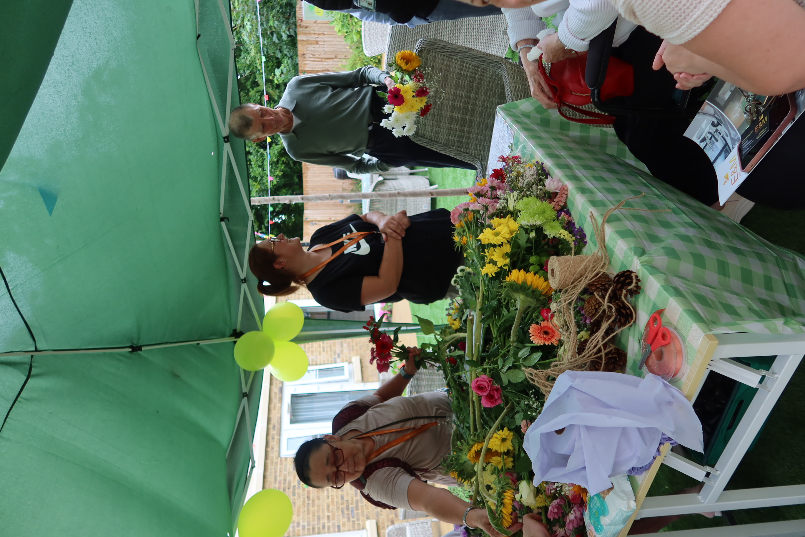 Flower arrangement station with Clients outside in the sunshine at Osbern Manor