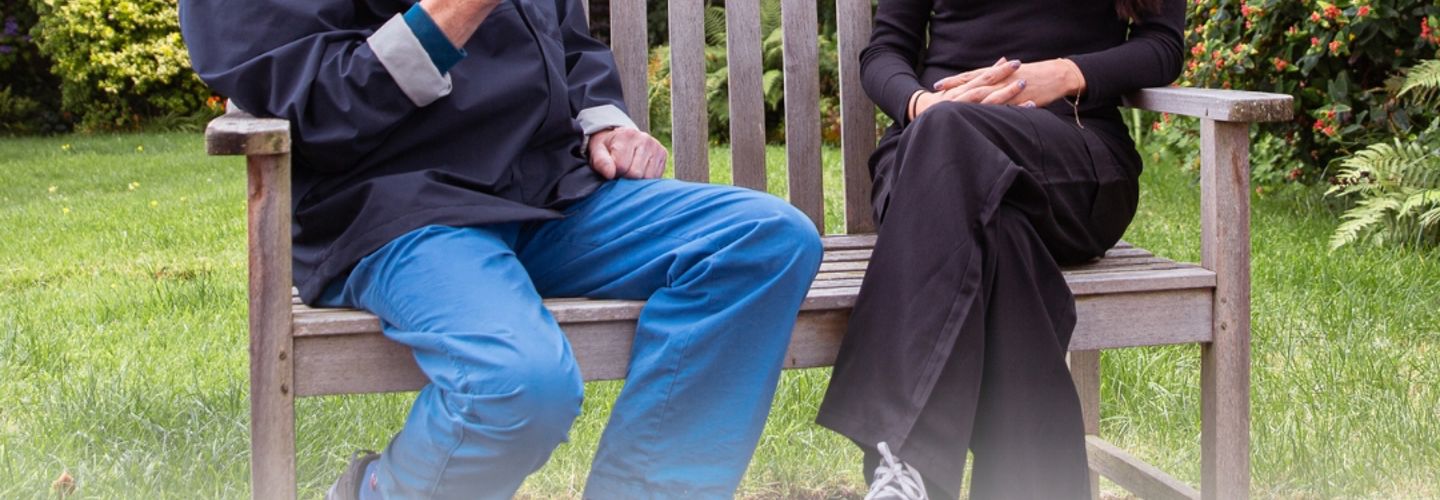 Carer enjoying a cup of coffee with a Client on a bench