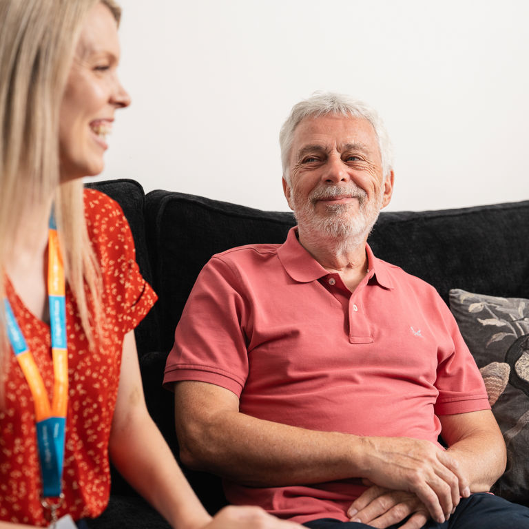 Carer and client sitting together and sharing a smiling moment