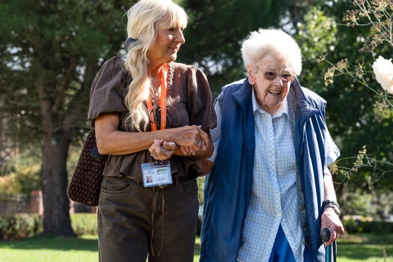 client and carer share a joyful moment outside in the community