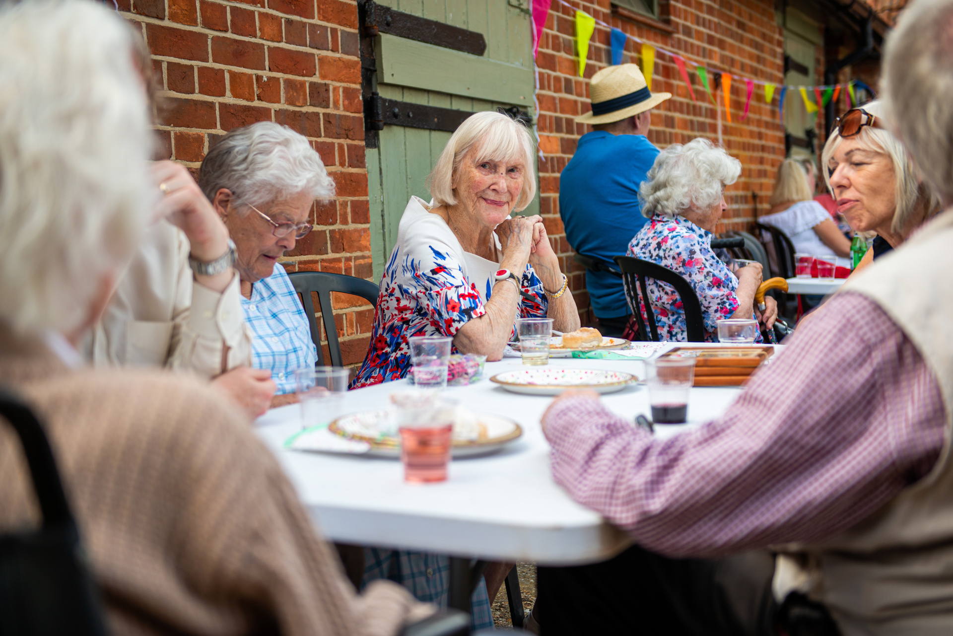 Client interacting with a community group at an outdoor tea party