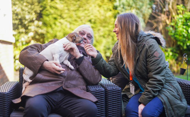 Client and CareGiver stroking dog