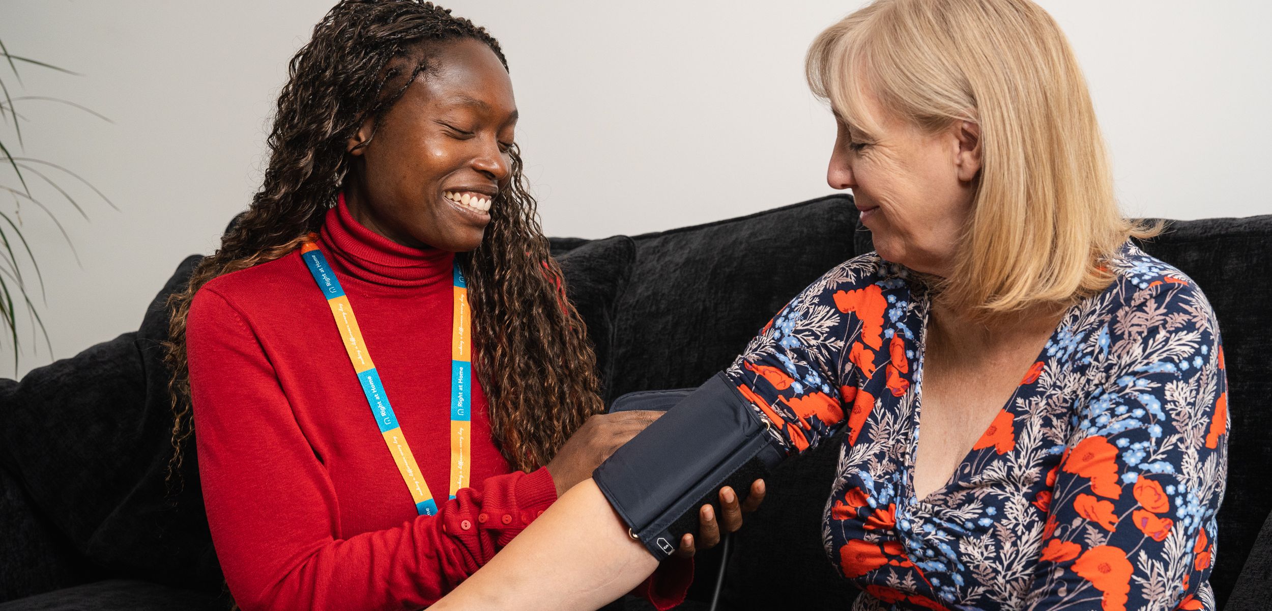 right-at-home-carer-helping-a-client-take-her-blood-pressure-measurements
