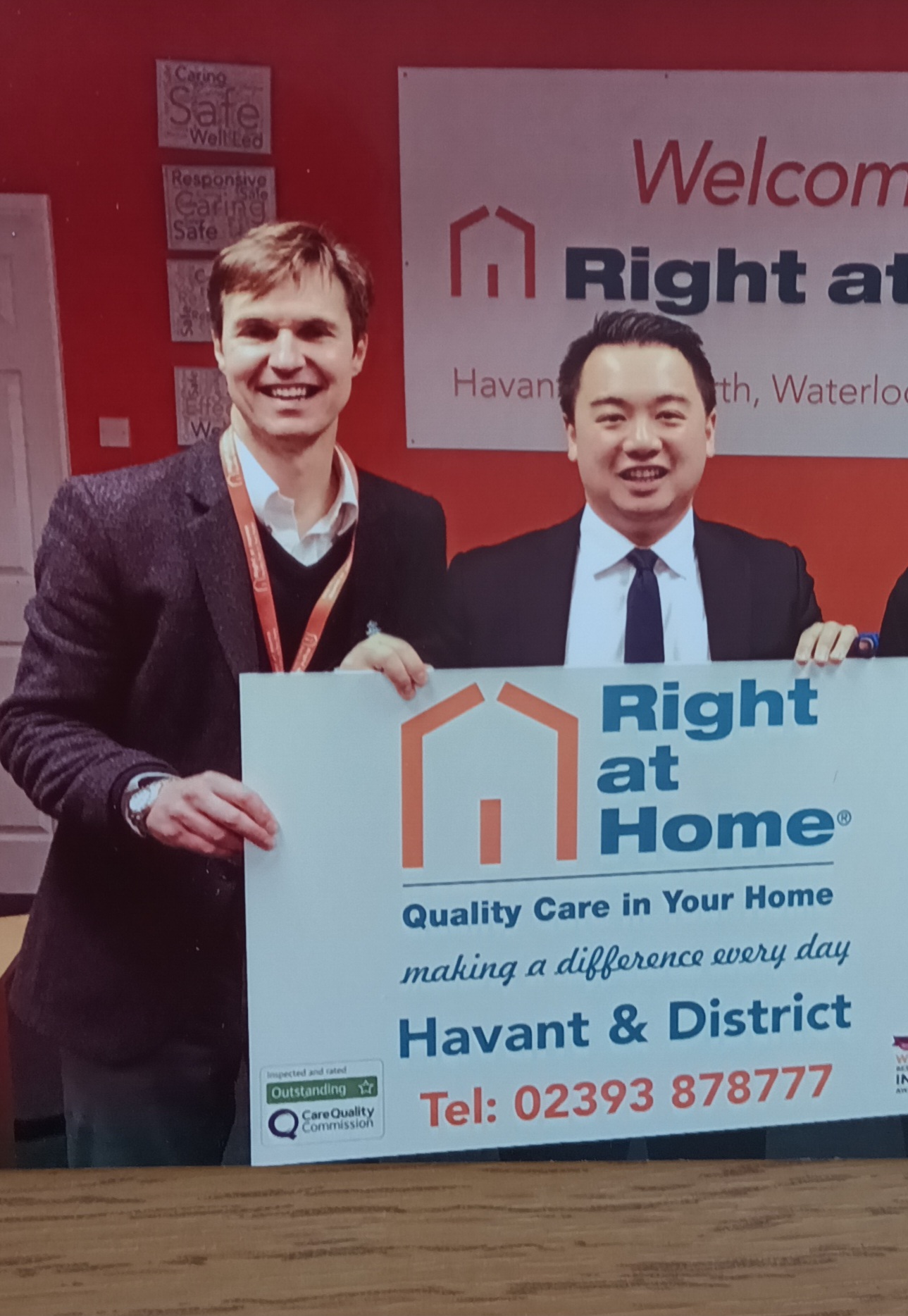 MP Alan Mak holds a sign with Duncan Cameron, Director celebrating two years in 2019
