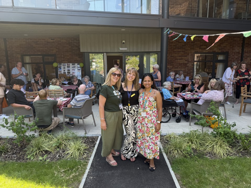 Right at Home Solent director with staff at the Big Green Picnic event, with clients and team members in the background.