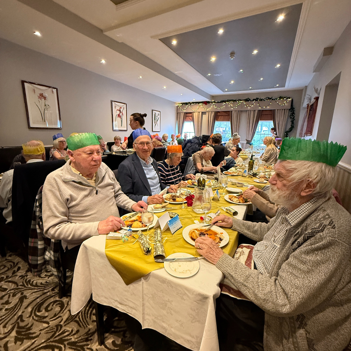 Clients enjoying a festive Christmas meal at Lysses House Hotel, seated at tables and sharing laughter during the 10th Client Christmas Meal hosted by Right at Home Solent.