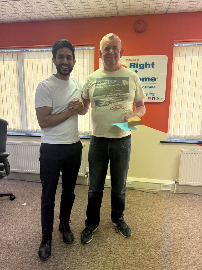 Fabian receiving his 10-year service award from Director Kev Popat at the Right at Home Solent office