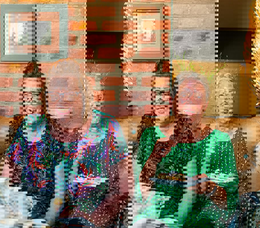 CareGiver and client in café eating cake and laughing