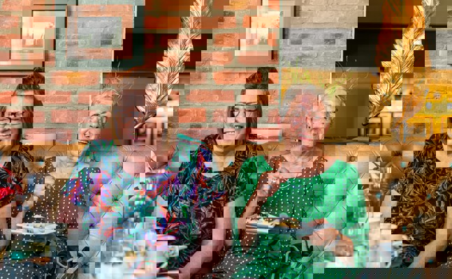 CareGiver and client in café eating cake and laughing