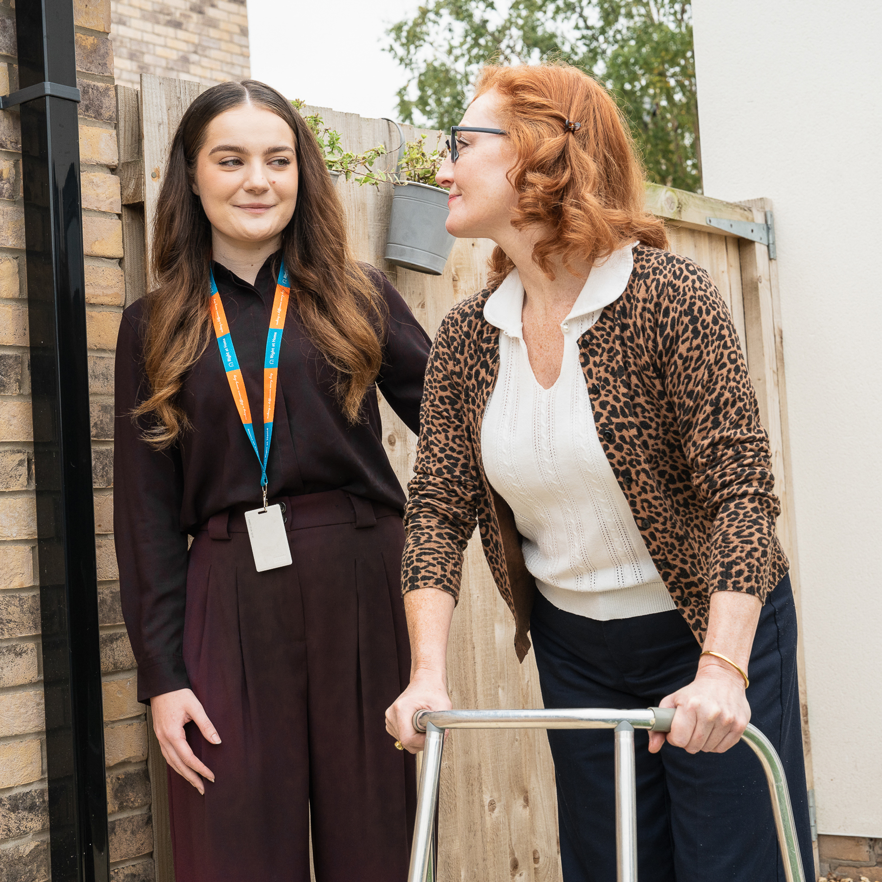 Carer supporting client using a walking frame