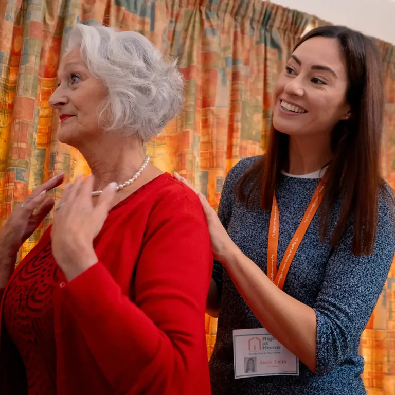 Carer supporting Client with personal care ahead of an evening with friends