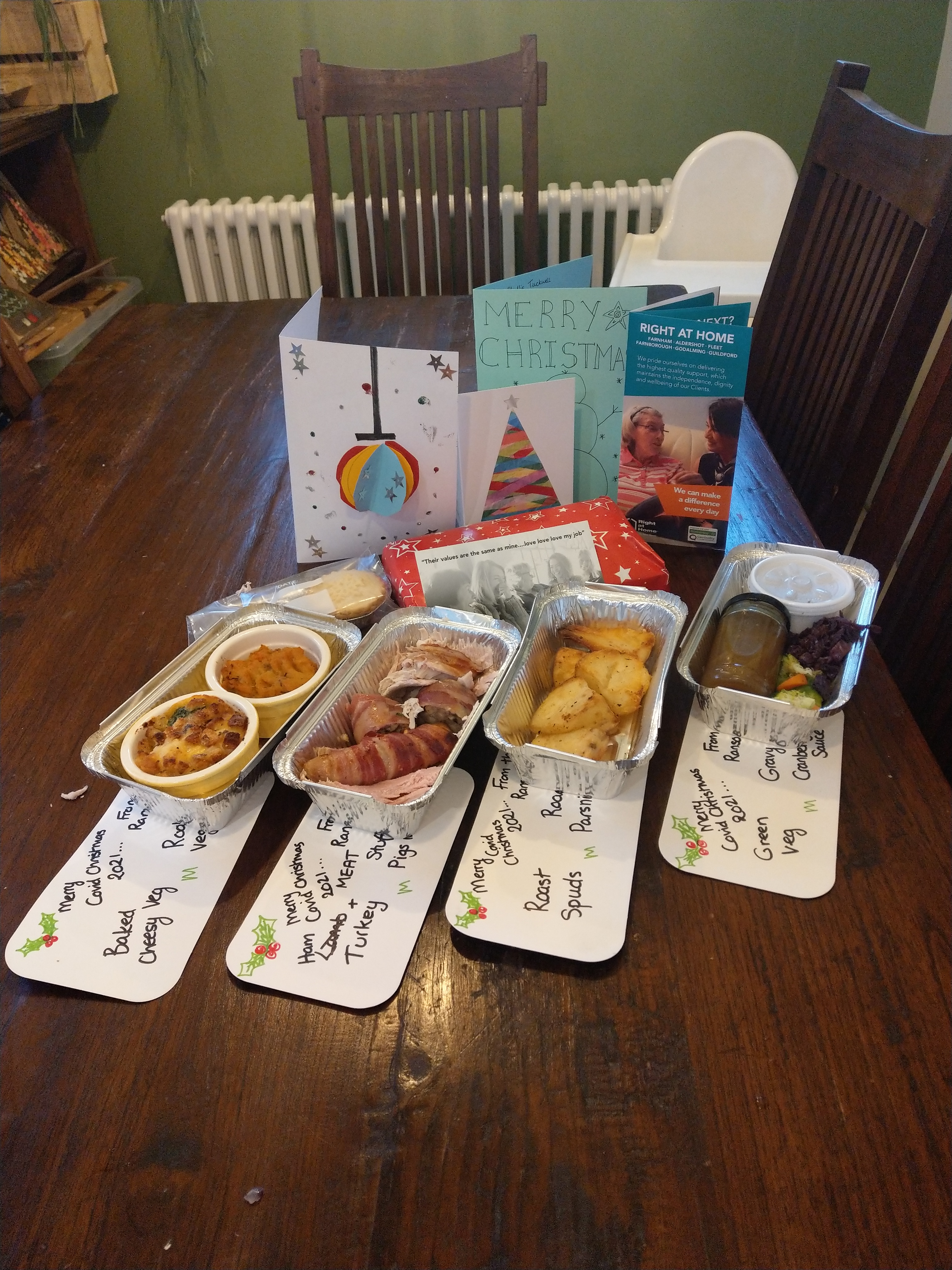 Greetings cards on a table and foil trays of food.