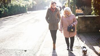 Carer walking with client down the road