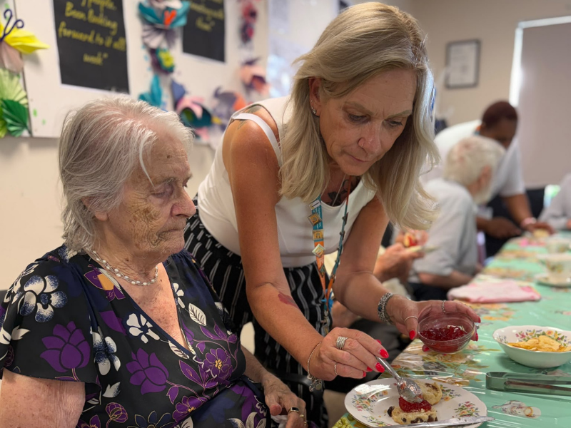 Right at Home Solent Office Manager Ali serving food to a client during an afternoon tea in Fareham
