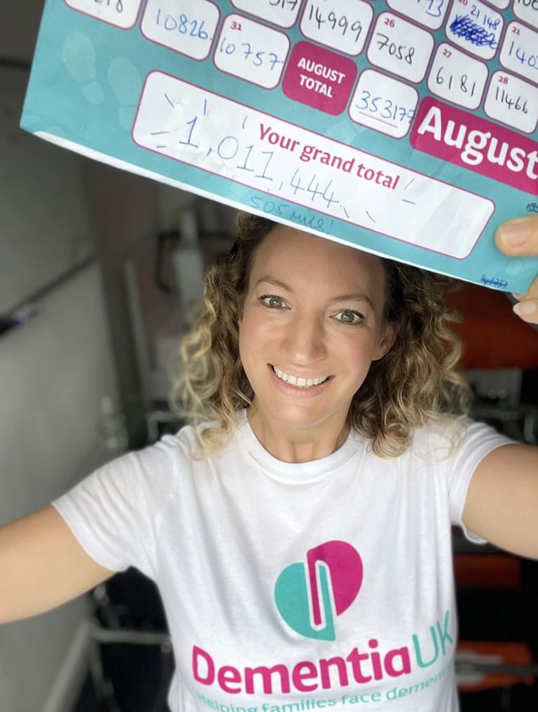 Rachel Critchley holding her Dementia UK sponsorship form celebrating the completion of one million steps for charity.