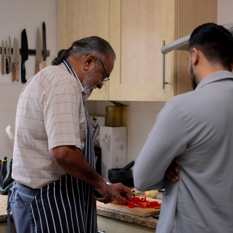 Carer assisting client who is preparing food
