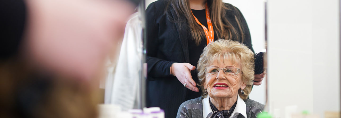CareGiver brushing Client's hair in mirror