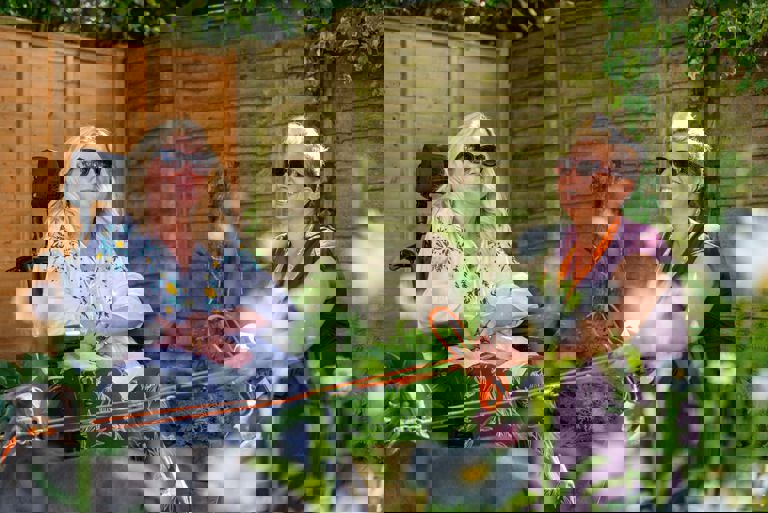 client and caregiver walking dog in garden