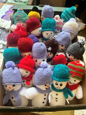 Box of knitted snowmen for community trail