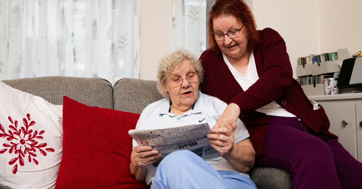 Independent elderly Client reading newspaper at home with Carer providing personalised homecare support in Fareham, Gosport, Southampton & New Forest East