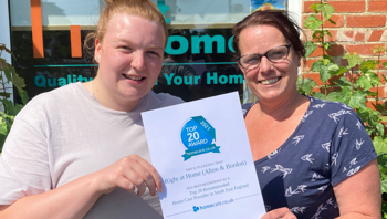 Two smiling females holding a certificate.