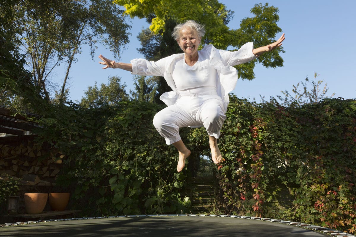 Elderly Lady Jumping on a Trampoline Smiling