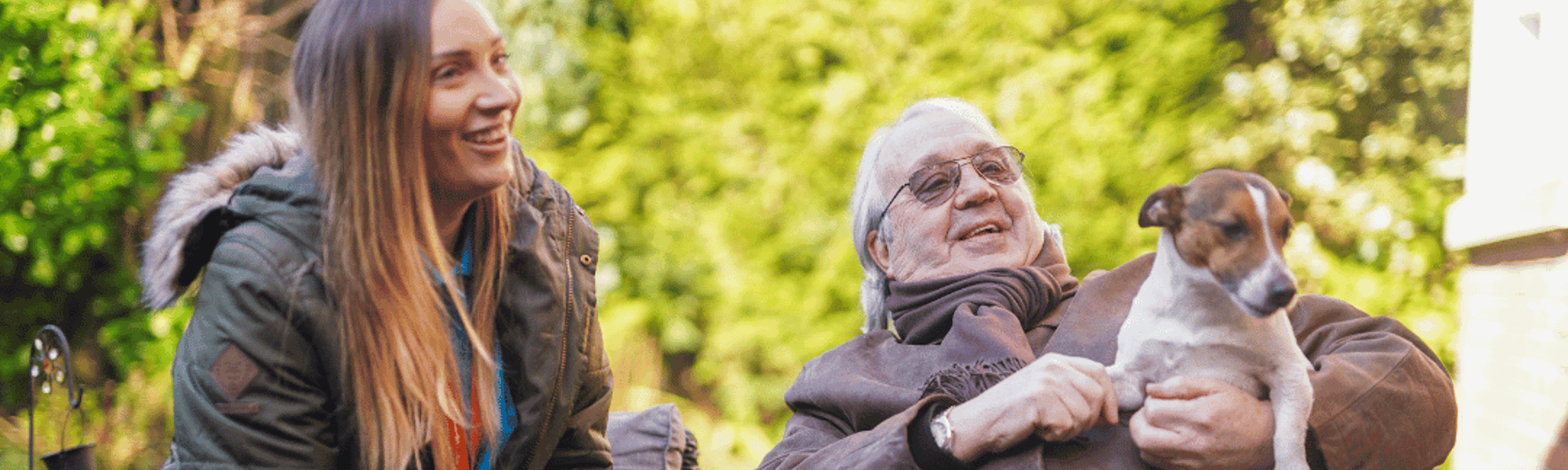 Woman and elderly gentleman sitting on a bench talking