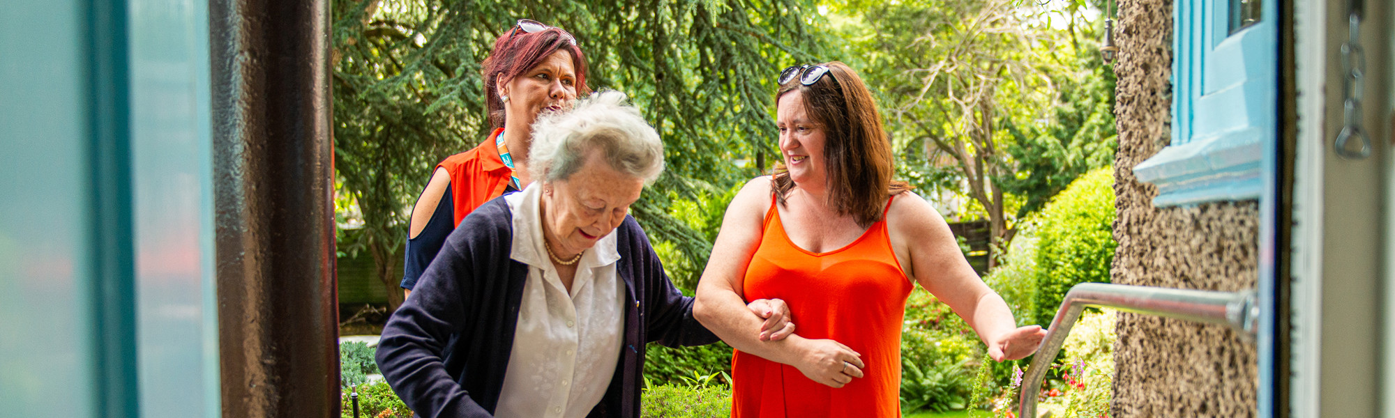 CareGivers helping client through doorway