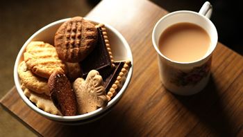 bowl of biscuits and cup of tea on a table