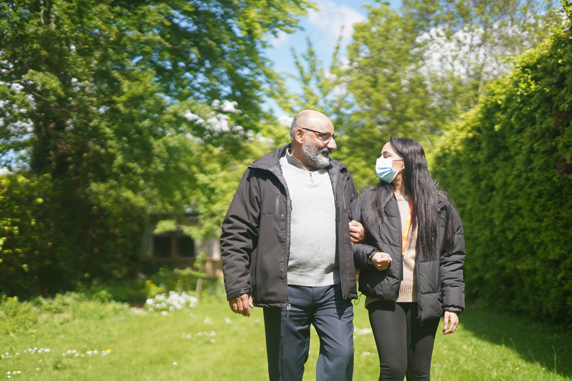 Client walking through a garden with a CareGiver