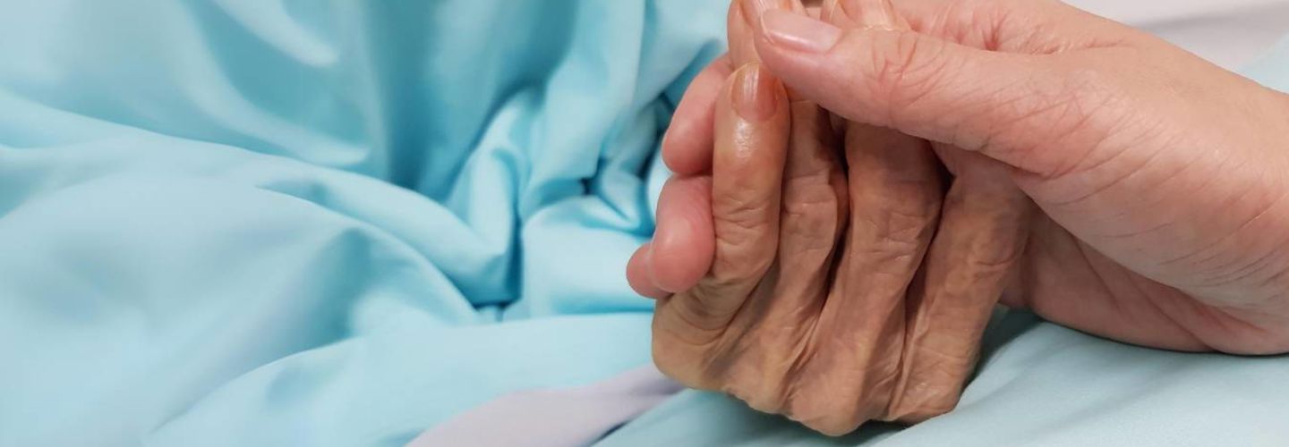 lady-holding-the-hand-of-an-older-lady-receiving-compassionate-end-of-life-care-at-home-in-cheshire-east