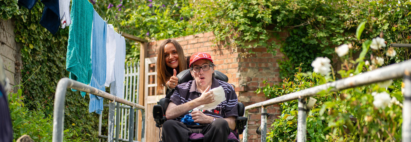 CareGiver pushing Client in wheelchair through garden