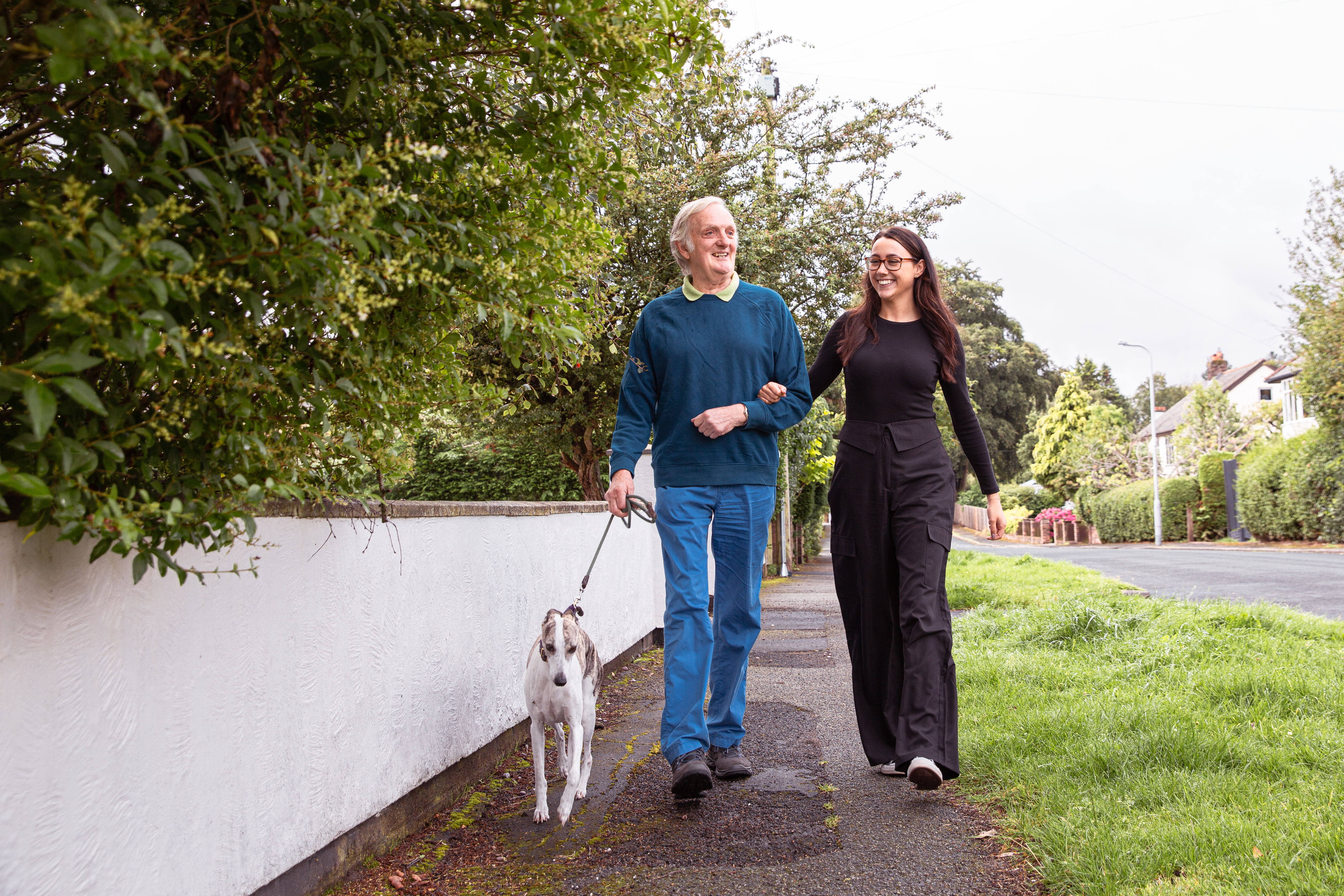 Man and lady walking a dog