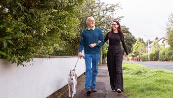 Man and lady walking a dog