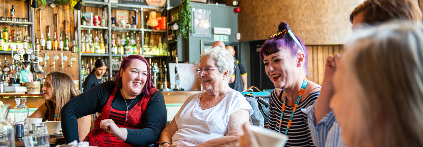 Elderly clients and care givers in a cafe
