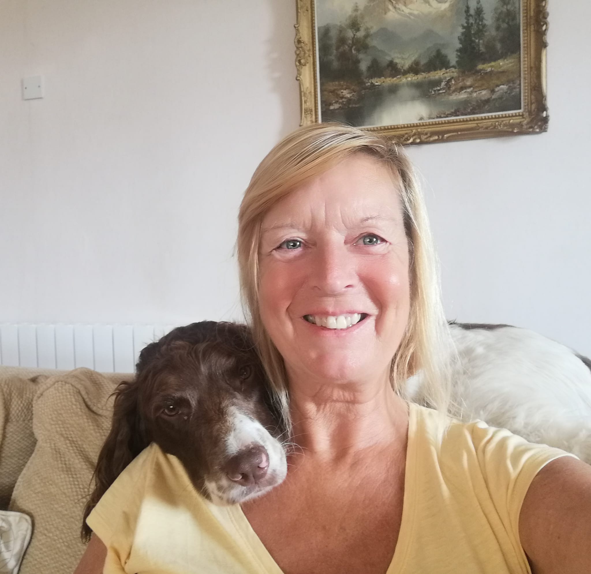 Kim and her dog sat on the sofa taking a selfie