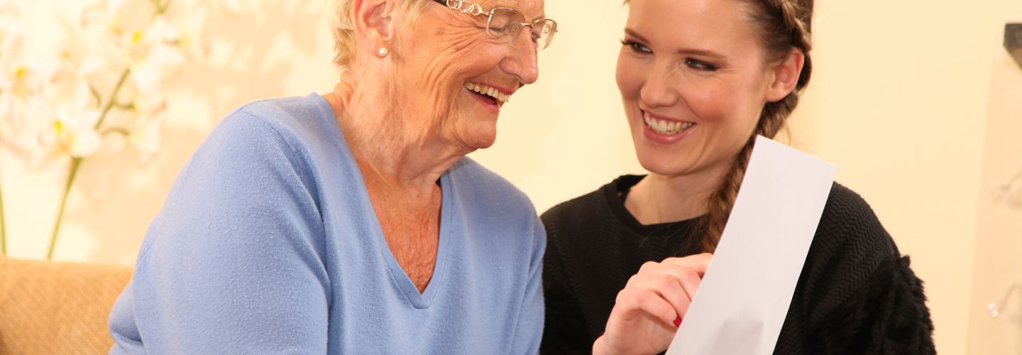 A carer and client smiling together